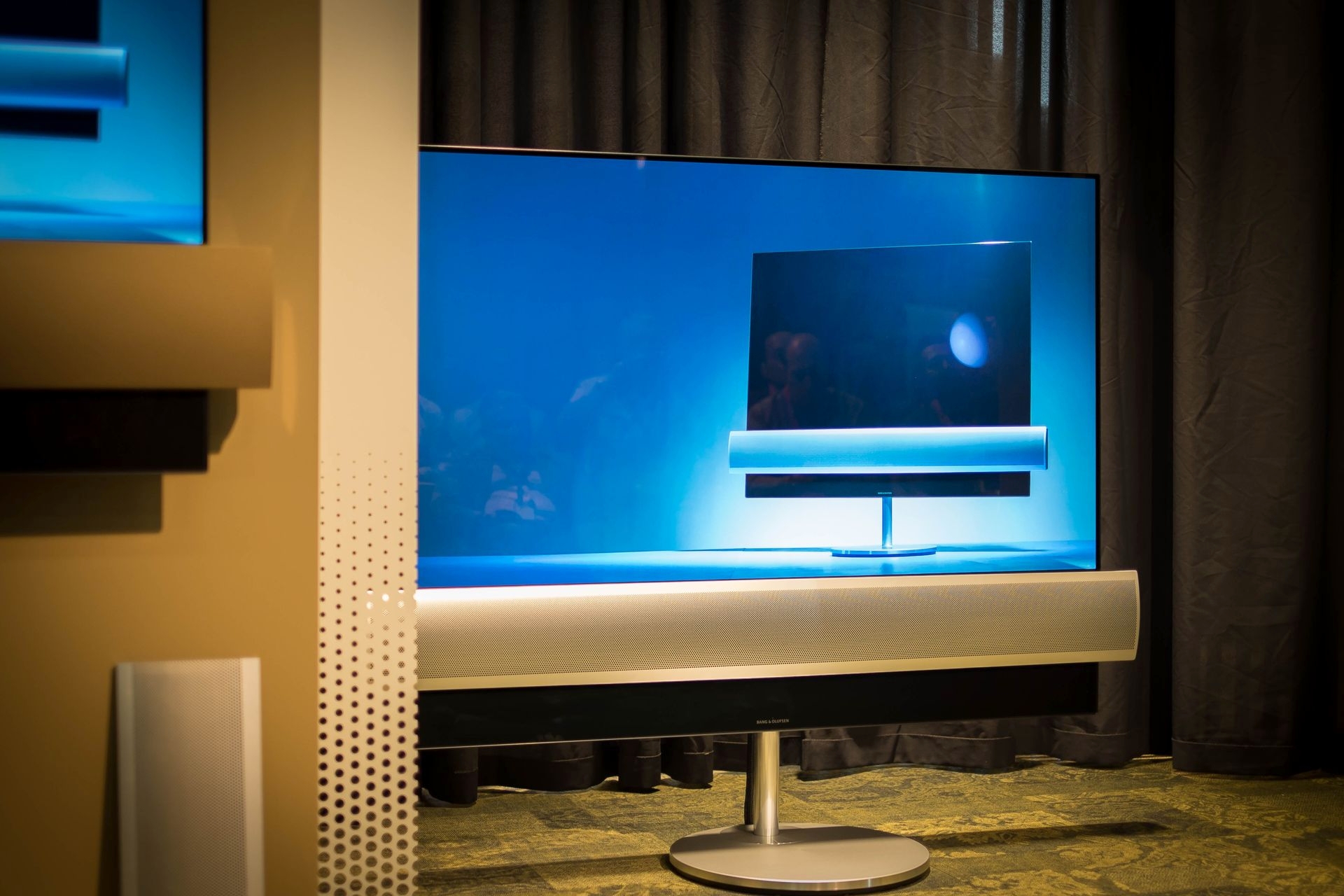 Der neue Beovision-Eclipse-OLED-Ferseher mit max. 65 Zoll Bildschirmdiagonale steht auf einem motoriserten Dreh- und Schwenk-Stativ. Es können je nach Geschmack verschiedene Materialen ausgewählt werden – beeindruckender Klang inbegriffen.