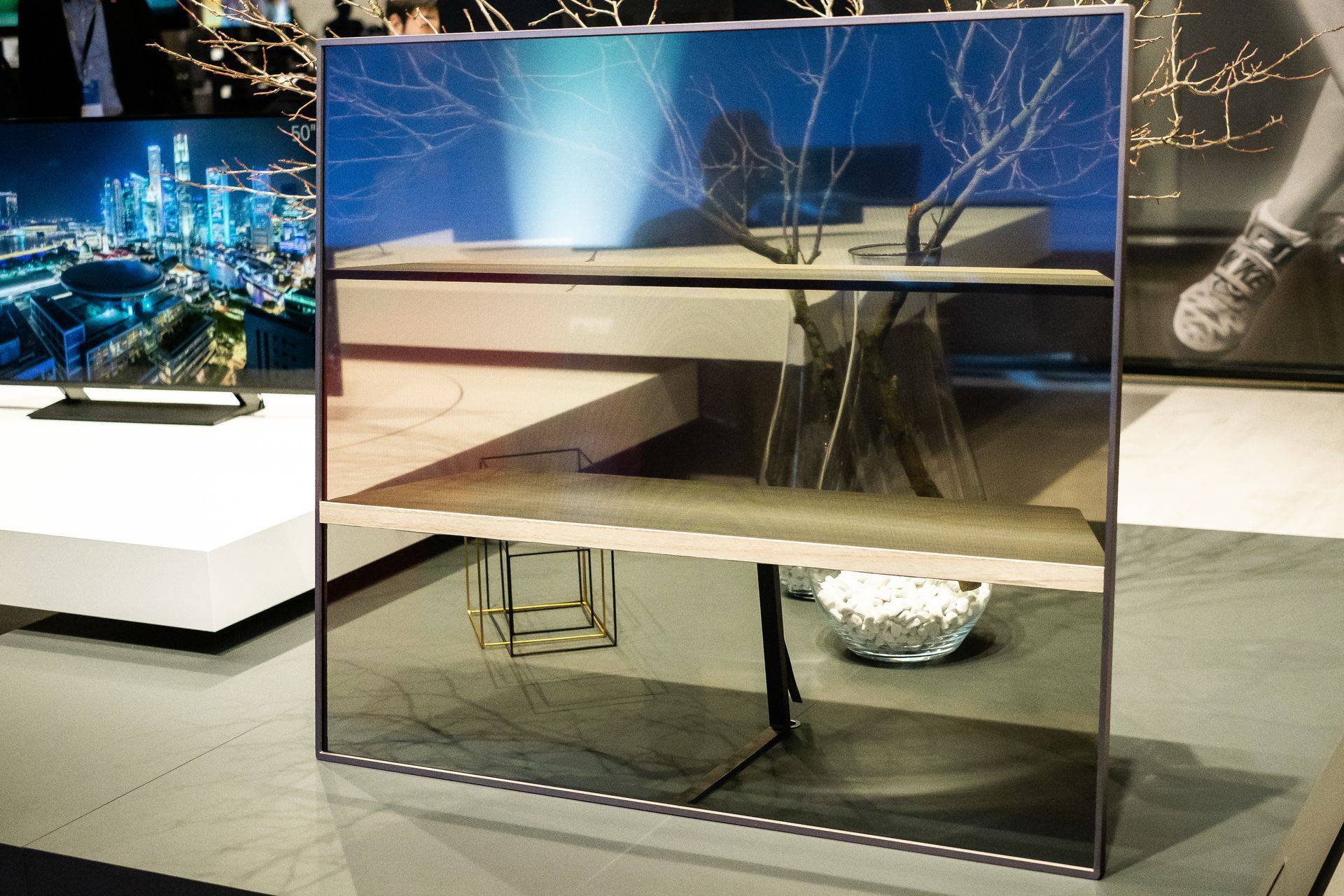 Mittlerweile der dritte Prototyp des transparenten TVs als Regal konzipiert. Die Bildqualität wird immer besser. Mit einer Markteinführung ist vorläufig noch nicht zu rechnen, aber die Marschrichtung ist klar, sonst würde das Konzept nicht prominent gezeigt.