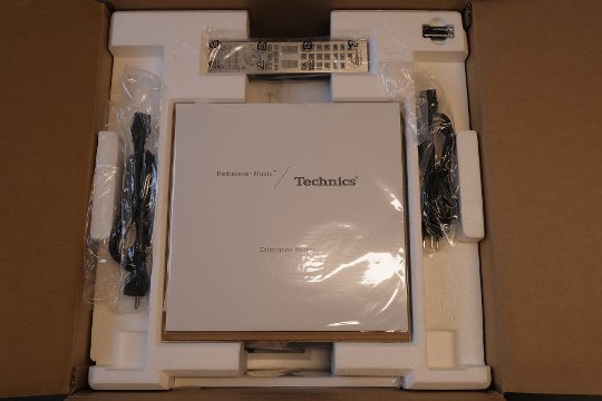 Unboxing: Nach dem Öffnen blickt man überrascht/gespannt auf eine Vinyl-Schallplatte für Einmess-Zwecke.