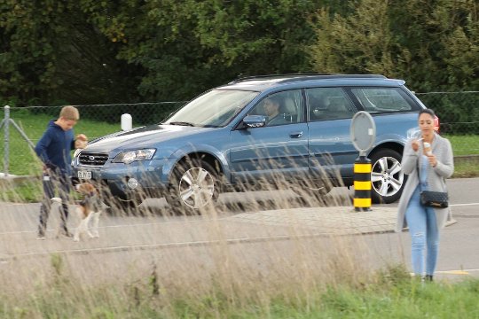 Canon EOS R7: Die Schärfe bleibt auch beim Mitschwenken der Fahrzeugbewegung und durch Vordergrund-Motive hindurch auf dem Fahrergesicht.