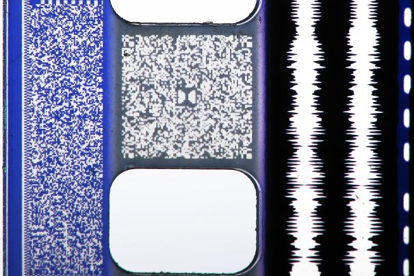 Tonspuren auf dem 35-mm-Film. Links und zwischen den Lochungen: digital; rechts: analoge Stereo-Spur (Bildquelle: https://commons.wikimedia.org).