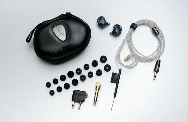 Im Lieferumfang enthalten sind neben den Hörern samt asymmetrischem Kabel ein Flugzeugadapter, ein vergoldeter Stecker-Konverter von 3,5 mm auf 6,3 mm, ein Reinigungsbürstchen, ein luxuriöses Case und zahlreiche Ohrpassstücke.