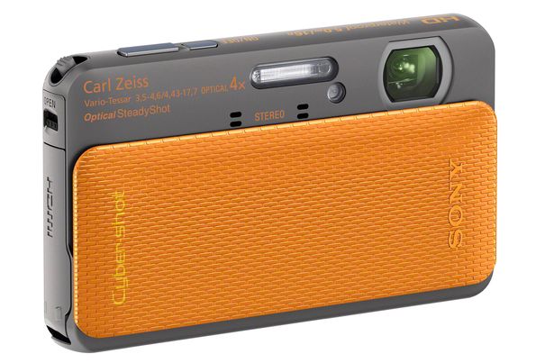 Die Sony TX20 ist die dünnste, verfügt aber dennoch über ein stabilisiertes 4x-Zoom hinter der hier orangen Objektivabdeckung. Sie gehört mit 16 Mpx zu den Modellen mit der höchsten Auflösung und besitzt einen Touchscreen.
